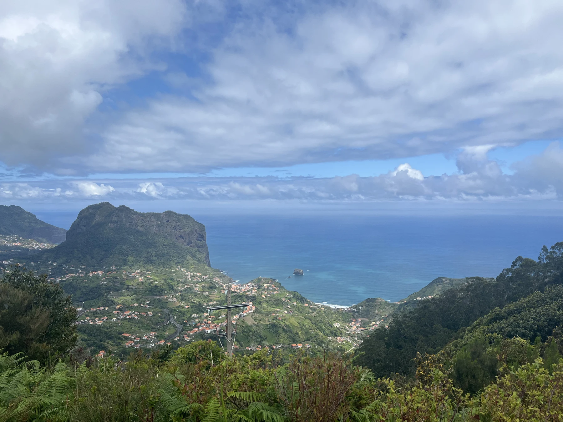 Blue Atlantic water beyond a coastal village and mountains in Madeira